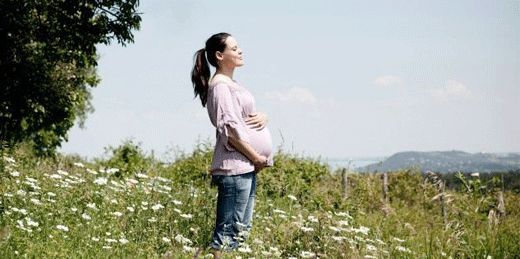 zwangere vrouw in grasveld